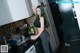 A woman standing in a kitchen next to a washing machine.