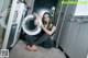 A woman sitting on the floor next to a washing machine.