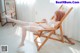 A woman sitting in a wooden chair in a room.