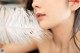 A woman with a white feather in her ear.