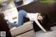 A woman laying on a couch in a hotel room.