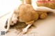 A woman laying on a bed with a teddy bear.