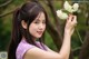 A woman holding a bunch of white flowers in her hand.