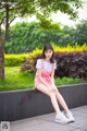 A woman sitting on a bench in a park.