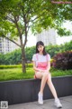 A woman sitting on a bench in a park.