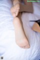 A close up of a woman's feet on a bed.