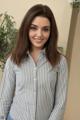 A woman in a striped shirt posing for a picture.