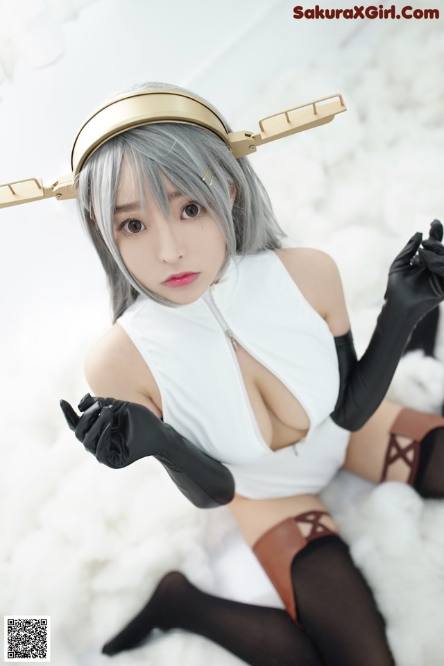 A woman in a white top and black gloves posing for a picture.