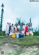 A group of young women posing for a picture in a field.