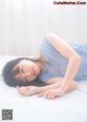 A woman laying on a bed in a blue dress.