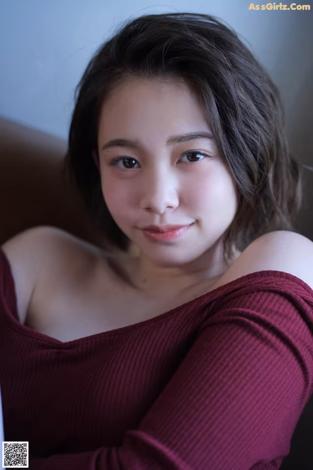 A woman in a red sweater is posing for a picture.