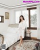 A woman standing in a bedroom next to a bed.