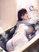 A woman in a bathtub with steam coming out of it.