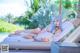 A woman laying on a lounge chair next to a pool.