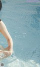 A woman in a swimming pool with her arms outstretched.