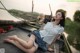 A woman sitting on top of a boat on a river.